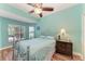 Bedroom featuring serene blue walls, ceiling fan, and large window offering a picturesque lake view at 5319 120Th E Ave, Parrish, FL 34219