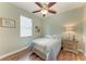 This cozy bedroom features hardwood floors, a ceiling fan, and a comfortable bed with bedside table at 5319 120Th E Ave, Parrish, FL 34219