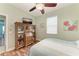 Comfortable bedroom featuring wood floors, a ceiling fan, and an antique hutch with shelves and display space at 5319 120Th E Ave, Parrish, FL 34219