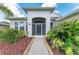 Welcoming front entrance with screened doorway surrounded by vibrant, tropical landscaping at 5319 120Th E Ave, Parrish, FL 34219