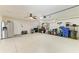 Spacious garage with epoxy flooring, shelving, storage, work benches and extra refrigerator at 5319 120Th E Ave, Parrish, FL 34219