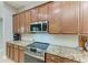 Close up of kitchen appliances and countertops showing granite counters, stainless steel oven and microwave, and custom cabinets at 5319 120Th E Ave, Parrish, FL 34219