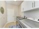Laundry room with modern washer and dryer, sink, white cabinets and tiled flooring at 5319 120Th E Ave, Parrish, FL 34219
