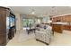 Open-concept living room features a large TV, neutral tones, and a sliding glass door to the outdoor space at 5319 120Th E Ave, Parrish, FL 34219
