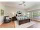 Main bedroom features wood floors, ceiling fan, many windows and views, and a luxurious king bed at 5319 120Th E Ave, Parrish, FL 34219