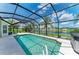 Sparkling pool inside a screened-in lanai with tranquil lake views, lush palm trees, and a spa at 5319 120Th E Ave, Parrish, FL 34219