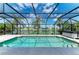 Sparkling pool inside a screened-in lanai with tranquil lake views, lush palm trees, and a spa at 5319 120Th E Ave, Parrish, FL 34219