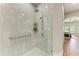 This modern tiled shower features a glass enclosure and convenient grab bar, seamlessly connecting to the bedroom at 5319 120Th E Ave, Parrish, FL 34219