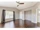This spacious bedroom has a ceiling fan, hardwood floors, and several windows with curtains at 5420 River Sound Ter, Bradenton, FL 34208