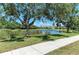 A pond is visible from a sidewalk with a view of a neighborhood and a clear blue sky at 5420 River Sound Ter, Bradenton, FL 34208