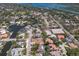 An aerial view shows a charming neighborhood with waterfront homes and lush green landscaping near the ocean at 5581 Shadow Lawn Dr, Sarasota, FL 34242