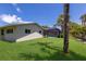 Backyard featuring a screened-in pool, lush lawn, and mature palm trees at 5581 Shadow Lawn Dr, Sarasota, FL 34242