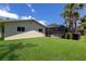Backyard featuring a screened-in pool, lush lawn, and mature palm trees at 5581 Shadow Lawn Dr, Sarasota, FL 34242