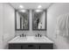 Modern bathroom featuring dual sinks, square mirrors and sleek gray cabinets at 5581 Shadow Lawn Dr, Sarasota, FL 34242