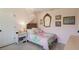 Cozy bedroom featuring a bed with a decorative canopy, antique mirror, and light pink walls at 5581 Shadow Lawn Dr, Sarasota, FL 34242
