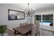 Bright dining room featuring a modern chandelier, gray walls, and sliding glass doors to the pool area at 5581 Shadow Lawn Dr, Sarasota, FL 34242