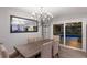 Open dining room with modern light fixture, view of the pool through sliding doors, and a large mirror accenting the space at 5581 Shadow Lawn Dr, Sarasota, FL 34242