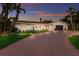 Charming home with a brick driveway and manicured lawn during a beautiful sunset at 5581 Shadow Lawn Dr, Sarasota, FL 34242