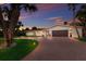 Charming home featuring a brick driveway, lush landscaping, and a two-car garage illuminated by a vibrant sunset at 5581 Shadow Lawn Dr, Sarasota, FL 34242