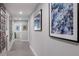 Long hallway adorned with many pictures and sleek floors leads to various rooms in this meticulously designed home at 5581 Shadow Lawn Dr, Sarasota, FL 34242