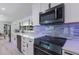 Beautiful kitchen with stone backsplash, stainless steel appliances, and breakfast bar at 5581 Shadow Lawn Dr, Sarasota, FL 34242