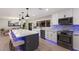Modern kitchen with stainless steel appliances, quartz counters, an island with seating, and contemporary lighting at 5581 Shadow Lawn Dr, Sarasota, FL 34242