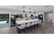 Modern kitchen featuring a large island with seating and stainless steel appliances with views of the pool at 5581 Shadow Lawn Dr, Sarasota, FL 34242