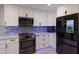 Modern kitchen featuring stainless steel appliances, mosaic backsplash, bright white cabinets, and ample countertop space at 5581 Shadow Lawn Dr, Sarasota, FL 34242