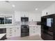 Well-lit kitchen featuring white cabinets, stainless appliances, and stylish backsplash at 5581 Shadow Lawn Dr, Sarasota, FL 34242