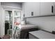 Functional laundry room with modern appliances, gray cabinets and ample counter space at 5581 Shadow Lawn Dr, Sarasota, FL 34242