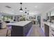Open concept living space with a large island, modern pendant lighting, and views into the cozy living room at 5581 Shadow Lawn Dr, Sarasota, FL 34242