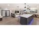 Open-concept living space showcasing a modern kitchen island flowing into the living and dining areas with sleek hardwood floors at 5581 Shadow Lawn Dr, Sarasota, FL 34242