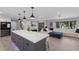 Open-concept living space with an island kitchen, pendant lighting, and a large comfortable sectional sofa at 5581 Shadow Lawn Dr, Sarasota, FL 34242
