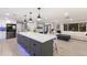 Open-concept living space showcasing a modern kitchen island flowing into the living and dining areas with sleek hardwood floors at 5581 Shadow Lawn Dr, Sarasota, FL 34242