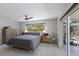 A serene main bedroom with wood accents, featuring a ceiling fan and backyard access at 5581 Shadow Lawn Dr, Sarasota, FL 34242