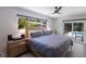 A serene main bedroom with backyard views, featuring a ceiling fan and wood accents at 5581 Shadow Lawn Dr, Sarasota, FL 34242