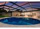 Beautiful pool with a screened-in enclosure, lounge chairs, and a dining area at 5581 Shadow Lawn Dr, Sarasota, FL 34242