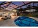 Relaxing pool area with a screened-in enclosure, lounge chairs, and outdoor dining under an umbrella and beautiful sunset views at 5581 Shadow Lawn Dr, Sarasota, FL 34242