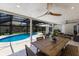 Covered outdoor patio with a dining table, ceiling fans, lounge seating, and a view of the pool at 5581 Shadow Lawn Dr, Sarasota, FL 34242