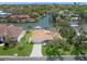 Aerial view of a waterfront home with a boat dock, surrounded by lush landscaping at 572 Commonwealth Ln, Sarasota, FL 34242