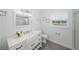Bright bathroom features a white vanity with marble countertop, flower vase, and toilet at 572 Commonwealth Ln, Sarasota, FL 34242
