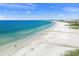 Stunning aerial view of a white sandy beach with clear turquoise water and beachfront buildings at 572 Commonwealth Ln, Sarasota, FL 34242