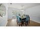 Elegant dining area with a glass table, stylish chairs, and views of the outdoor pool and waterfront at 572 Commonwealth Ln, Sarasota, FL 34242