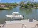Waterfront dock with a boat lift on a sunny day, offering direct access to the serene canal waters at 572 Commonwealth Ln, Sarasota, FL 34242