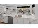 Bright kitchen features white cabinets, stainless appliances, and a large window view of the outdoor pool at 572 Commonwealth Ln, Sarasota, FL 34242