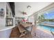 Enclosed outdoor dining area features a long wooden table and a clear view of the pool and canal at 572 Commonwealth Ln, Sarasota, FL 34242