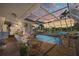Relaxing screened pool with dining area and waterfront views at dusk at 572 Commonwealth Ln, Sarasota, FL 34242