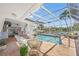 Outdoor pool area features a screened enclosure, comfortable lounge furniture, and waterfront views at 572 Commonwealth Ln, Sarasota, FL 34242