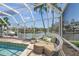Covered outdoor patio lounge area with water views, overlooking the pool and canal at 572 Commonwealth Ln, Sarasota, FL 34242