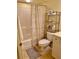 This bathroom features a standard tub-shower combination, toilet, and a metal shelving unit at 600 Mirabella Cir # 201, Venice, FL 34292